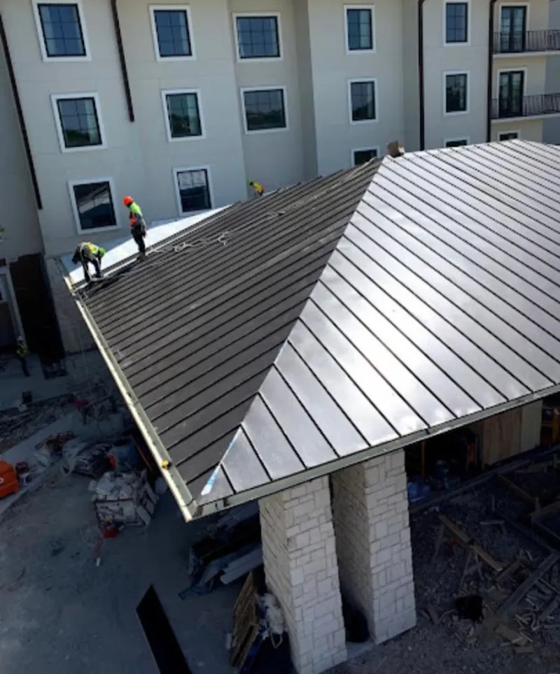 Crew installing standing seam metal roof panels on a commercial project in Lomita